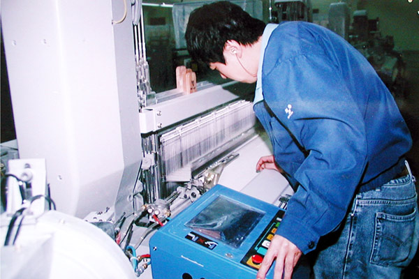 公司技工正在对布机进行调试